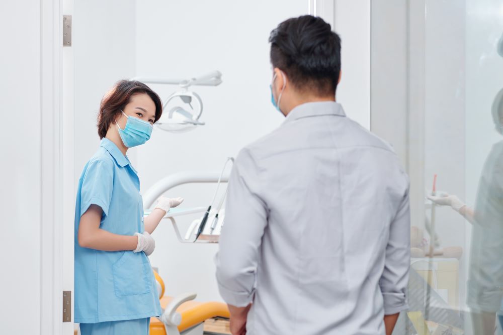 dental-nurse-inviting-patient-ESXZZV3