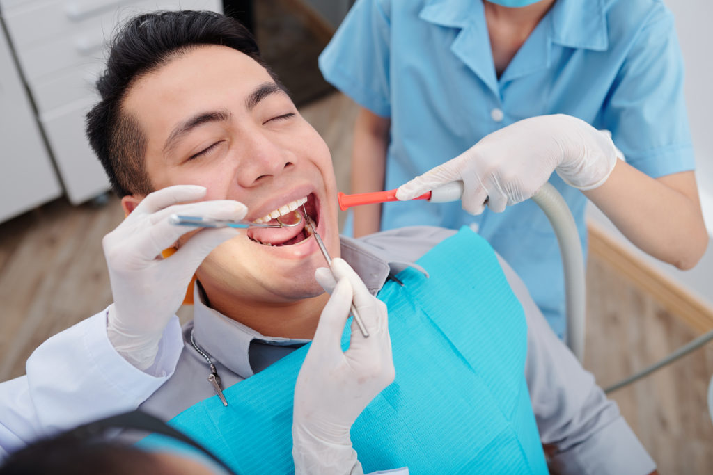 dentist treating teeth of patient QMBDRY3